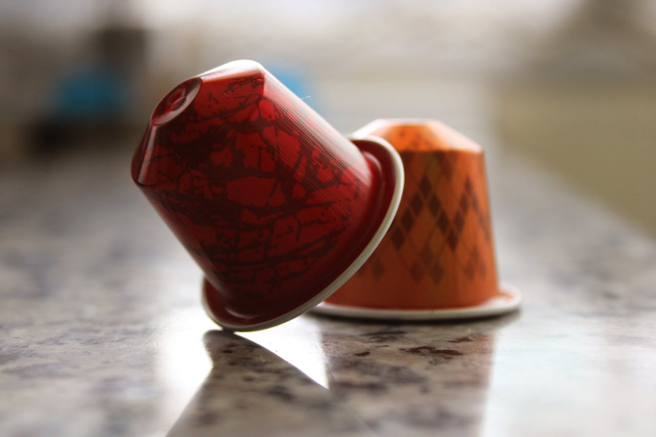 Close-up of decorative coffee capsules on a marble countertop in warm light.