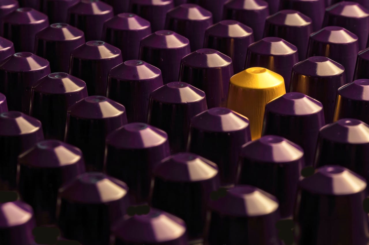 An artistic display of purple coffee pods with a standout gold pod.