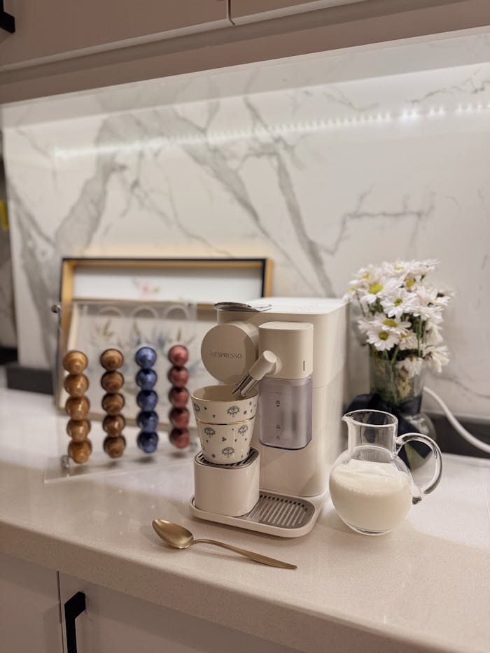 Elegant home coffee corner with a Nespresso machine, capsules, and milk jug in Kocaeli, Türkiye.